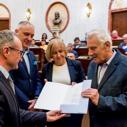 Grzegorz Boski, wicemarszałek Śląska, wręcza dokument radnomu Marek Bieniekowi, symbolizując wspieranie 40 Rodzinnych Ogrodów Działkowych w regionie. (wygenerowano przez AI)