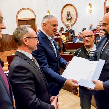 Grzegorz Boski, wicemarszałek Województwa Śląskiego, wręcza certyfikaty 40 rodzinom działkowym podczas uroczystości w Sali Sejmu Śląskiego. (wygenerowano przez AI)
