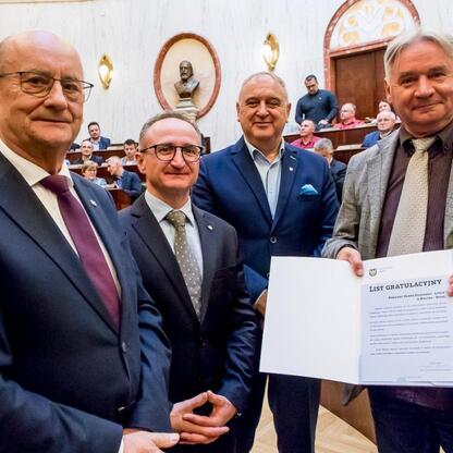 Grzegorz Boski, wicemarszałek, wręcza certyfikaty na ceremonii wsparcia Rodzinnych Ogrodów Działkowych w Sali Sejmu Śląskiego. (wygenerowano przez AI)