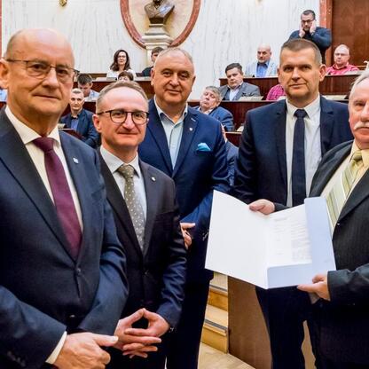 Wicemarszałek Grzegorz Boski wręcza certyfikaty 40 rodzinom działkowym z Marszałkowskiego Programu dla Ogrodów Działkowych. (wygenerowano przez AI)