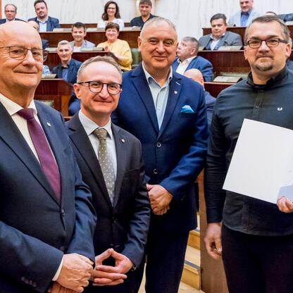 Grzegorz Boski, wicemarszałek, prezentuje dokument na ceremonii w Silesia Sejm Chamber, podczas której odbierają dofinansowanie dla Rodzinnych Ogrodów Działkowych. (wygenerowano przez AI)