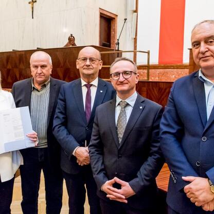 Grzegorz Boski, wicemarszałek, wręcza umowy o dofinansowanie dla 40 rodzinnych ogrodów działkowych w Sali Sejmu Śląskiego. (wygenerowano przez AI)