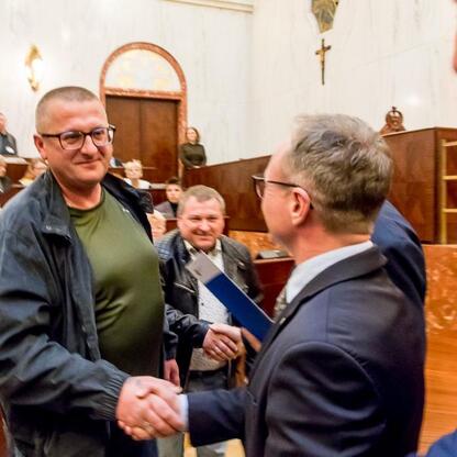 Wicemarszałek Grzegorz Boski i radni Sejmiku Województwa Śląskiego wręczają certyfikaty zwycięzcom konkursu Rodzinnych Ogrodów Działkowych w Sali Sejmu Śląskiego. (wygenerowano przez AI)
