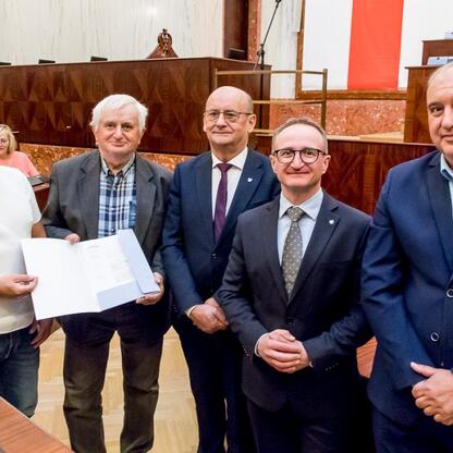 Grzegorz Boski, wicemarszałek, wręcza umowy w Sali Sejmu Śląskiego. (wygenerowano przez AI)