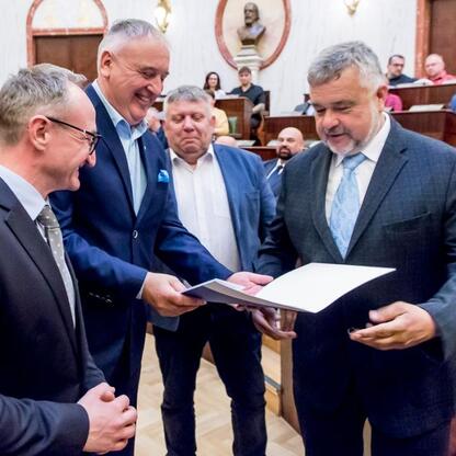Wicemarszałek Grzegorz Boski prezentuje certyfikaty w Sali Sejmu Śląskiego. (wygenerowano przez AI)
