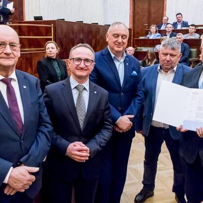 Grzegorz Boski, wicemarszałek, wręcza certyfikaty na uroczystości w Sali Sejmu Śląskiego. (wygenerowano przez AI)