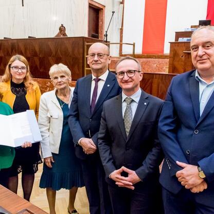 Wicemarszałek Grzegorz Boski i radni Sejmiku Województwa Śląskiego wręczają certyfikaty w Sali Sejmiku Województwa Śląskiego. (wygenerowano przez AI)