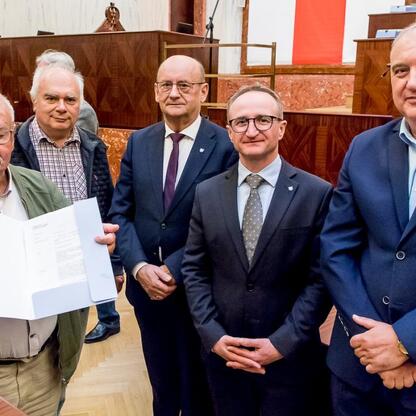 Grzegorz Boski, wicemarszałek Śląskiego, wręcza dokumenty podczas ceremonii wsparcia rodzinnych ogrodów działkowych. (wygenerowano przez AI)
