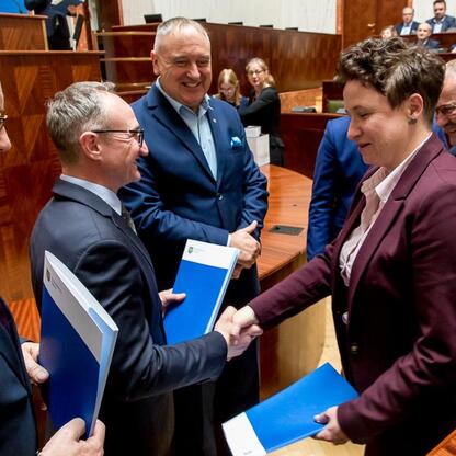 Wicemarszałek Grzegorz Boski przekazuje umowy na realizację projektów Sołeckiej Inicjatywy w Sali Sejmu Śląskiego. (wygenerowano przez AI)