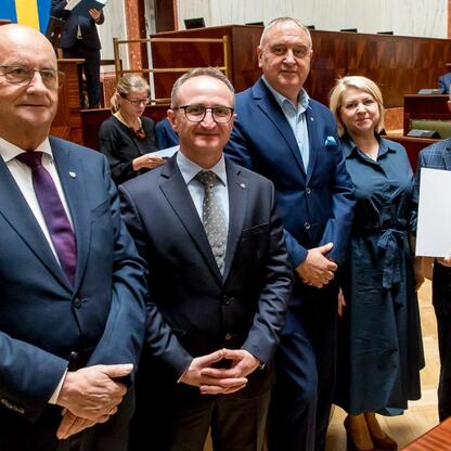 Grzegorz Boski, wicemarszałek, prezentuje dokumenty, podpisując umowy Inicjatywy Sołeckiej w Sali Sejmu Śląskiego. (wygenerowano przez AI)