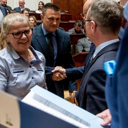 W Sali Sejmu Śląskiego przedstawiciele gmin odbierają dokumenty z projektów Sołeckiej Inicjatywy. (wygenerowano przez AI)