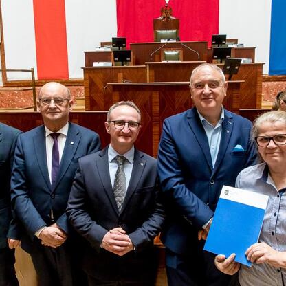 Grzegorz Boski, wicemarszałek, wręcza umowy w Sali Sejmu Śląskiego. (wygenerowano przez AI)