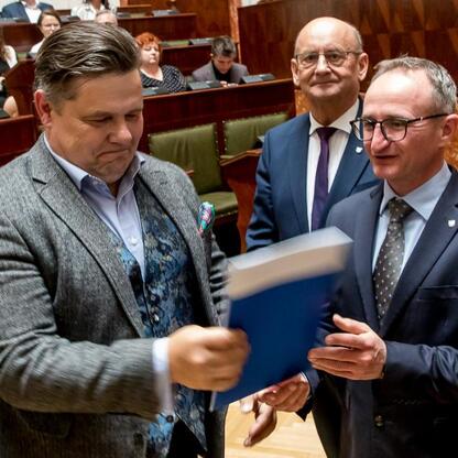 Wicemarszałek Grzegorz Boski wręcza dokumenty Sołectwa Initiative w Sali Sejmu Śląskiego. (wygenerowano przez AI)