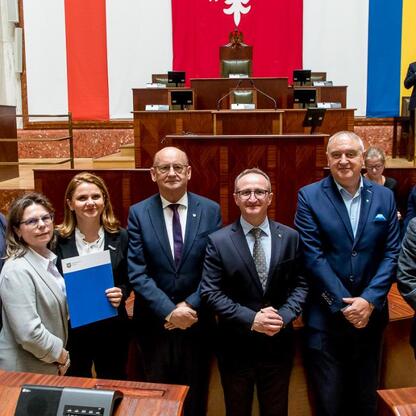 Grzegorz Boski, wicemarszałek, wręcza dokumenty Sołectwa Initiative w Sali Sejmu Śląskiego. (wygenerowano przez AI)