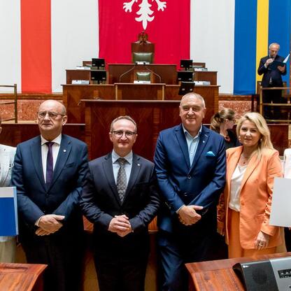 Grzegorz Boski, wicemarszałek, wręcza umowy w Sali Sejmu Śląskiego. (wygenerowano przez AI)