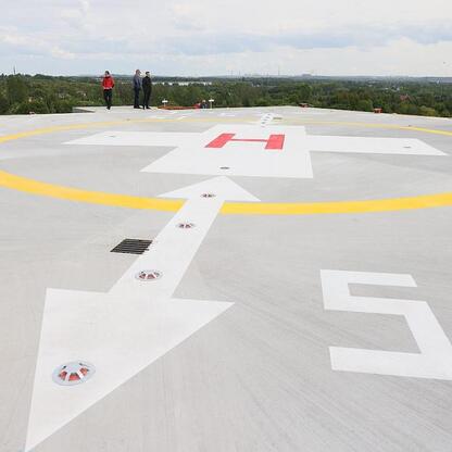 Helipad na dachu Szpitalnego Oddziału Ratunkowego w Sosnowcu, zaznaczony znakami i kierunkami, w ramach inwestycji w ochronę zdrowia regionu. (wygenerowano przez AI)