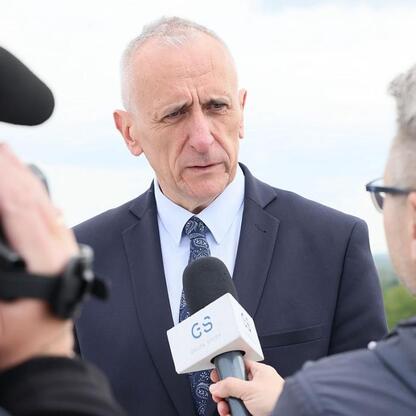 Wicemarszałek Leszek Pietraszek w rozmowie z dziennikarzem o otwarciu helipadu dla helikopterów ratunkowych w Centrum Zdrowia Dziecka i Rodziny im. Jana Pawła II w Sosnowcu. (wygenerowano przez AI)