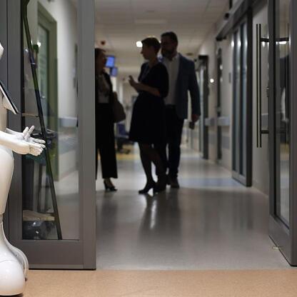Pepper robot w szpitalnym korytarzu, wspierający pielęgniarki i pacjentów. (wygenerowano przez AI)