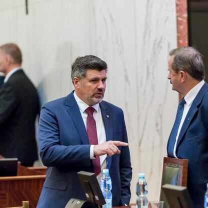 Dwa parlamentarzyści w rozmowie w sali posiedzeń Sejmiku Śląskiego, omawiają Krajowy Plan Odbudowy i budżet 2025. (wygenerowano przez AI)