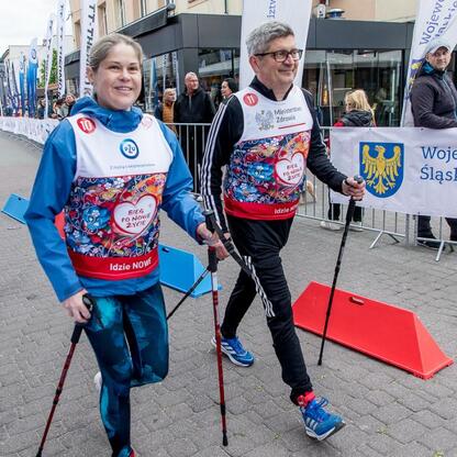 Zdjęcie przedstawia uczestników 26. Biegu po Nowe Życie, wspierającego polską transplantologię, w trakcie nordic walking. (wygenerowano przez AI)