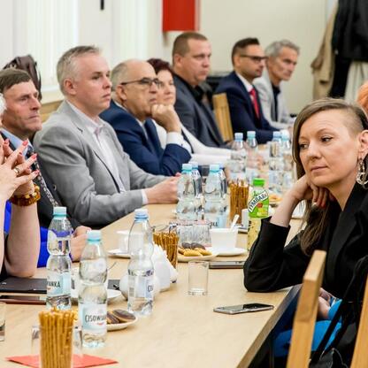 Formalna sesja w konferencyjnym pomieszczeniu, uczestnicy z regionu Północnego, wspieranie lokalnych inicjatyw. (wygenerowano przez AI)
