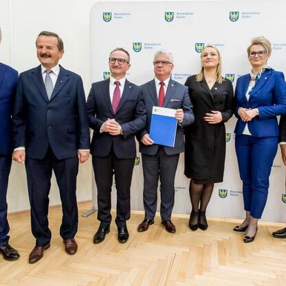 Grzegorz Boski, wicemarszałek, wręcza umowy sołectwom w ramach Inicjatywy Sołecka w Starostwie Powiatowym w Częstochowie. (wygenerowano przez AI)