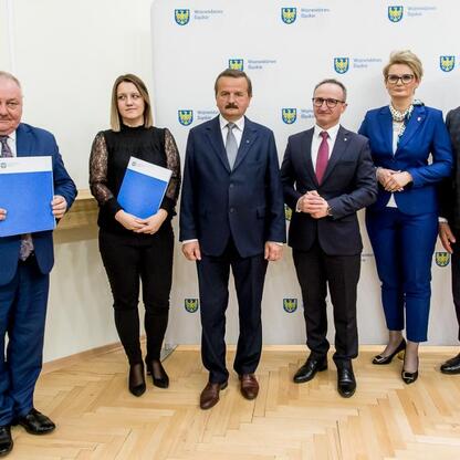 Grzegorz Boski, wicemarszałek Śląskiego Voivodztwa, wraz z kolegami podczas ceremonii wręczenia umów w ramach programu Inicjatywa Sołecka. (wygenerowano przez AI)