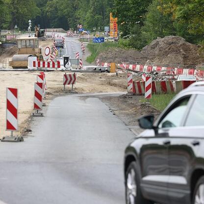 Modernizacja drogi wojewódzkiej nr 928 w regionie Śląskim. Prace obejmują przebudowę nawierzchni, ujednolicenie szerokości jezdni i budowę chodników. (wygenerowano przez AI)