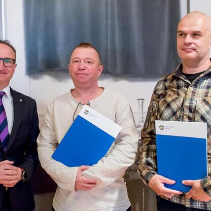 Trzech uczestników województwa Śląskiego podczas ceremonii wręczenia umów z programu Owca Plus. (wygenerowano przez AI)