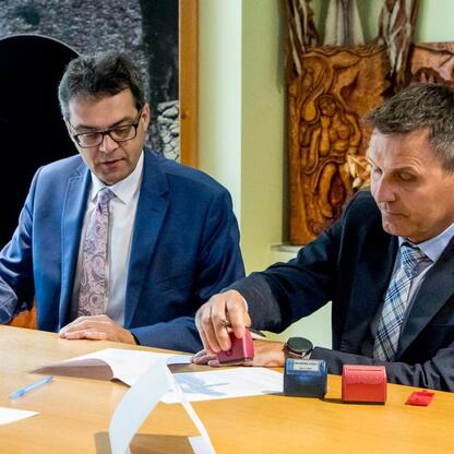Dwóch mężczyzn podpisuje umowy w Centrum Kultury i Sztuki 