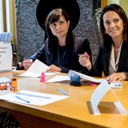 Dwie kobiety w rozmowie w sali konferencyjnej, podpisują umowy w ramach Marszalkowskiego Konkursu 'Inicjatywa Sołecka' 2025. (wygenerowano przez AI)