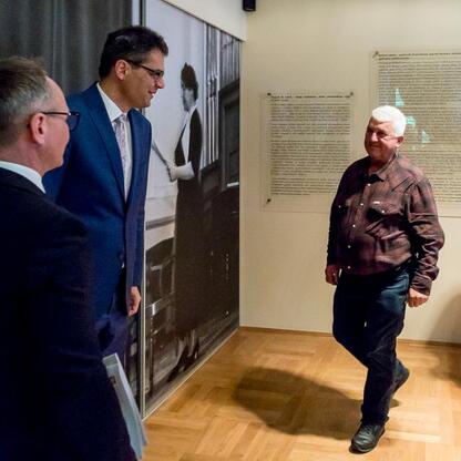 W muzeum, ludzie omawiają wystawę, podkreślając jej elementy. (wygenerowano przez AI)