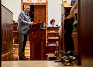 Konferencja o stwardnieniu rozsianym w Sali Sejmikowej, gdzie kobieta w białym płaszczu przemawia do publiczności. (wygenerowano przez AI)