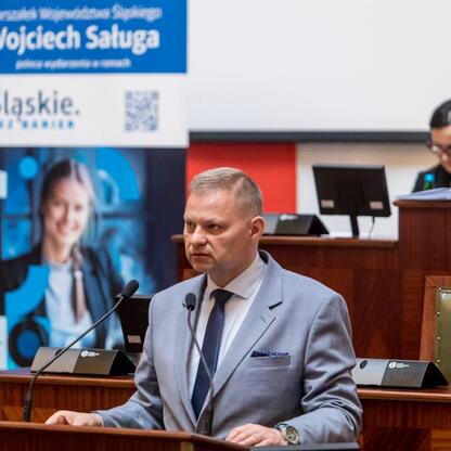 Członek Zarządu Województwa Śląskiego, Rafał Adamczyk, przemawia na konferencji o stwardnieniu rozsianym w Sali Sejmu Śląskiego. (wygenerowano przez AI)