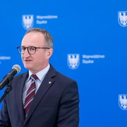 Grzegorz Boski, wicemarszałek Województwa Śląskiego, przemawia na podium w Urzędzie Marszałkowskim. (wygenerowano przez AI)