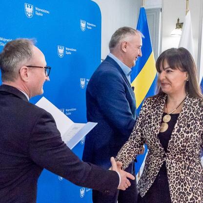 Wicemarszałek Grzegorz Boski i Marek Bieniek uczestniczą w uroczystym przekazaniu umów na modernizację dróg dojazdowych do terenów wiejskich w Urzędzie Marszałkowskim Województwa Śląskiego. (wygenerowano przez AI)