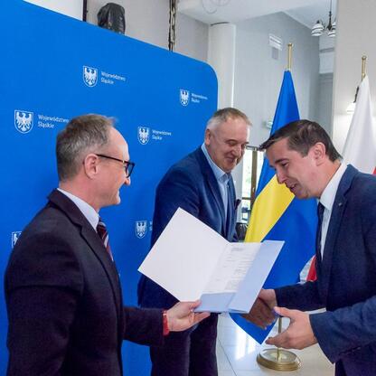 Wicemarszałek Grzegorz Boski wręcza umowy na modernizację dróg dojazdowych do terenów wiejskich. (wygenerowano przez AI)