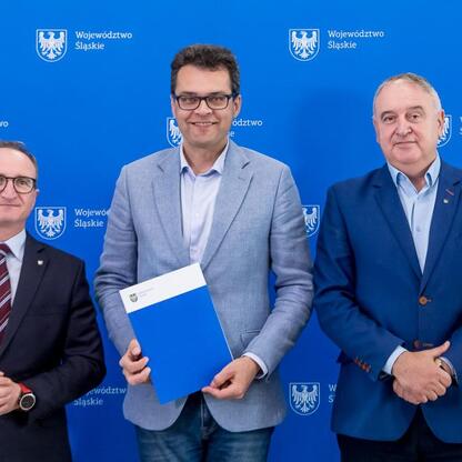 Grzegorz Boski, wicemarszałek Województwa Śląskiego, prezentuje dokumenty, podczas uroczystości przekazania umów na modernizację dróg dojazdowych do terenów wiejskich. (wygenerowano przez AI)