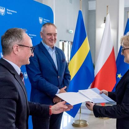 Wicemarszałek Grzegorz Boski przekazuje dokumenty przedstawicielom samorządów, modernizując drogi do terenów wiejskich. (wygenerowano przez AI)