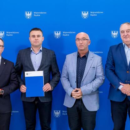 Grzegorz Boski, wicemarszałek Województwa Śląskiego, prezentuje umowy modernizacji dróg dojazdowych do terenów wiejskich. (wygenerowano przez AI)