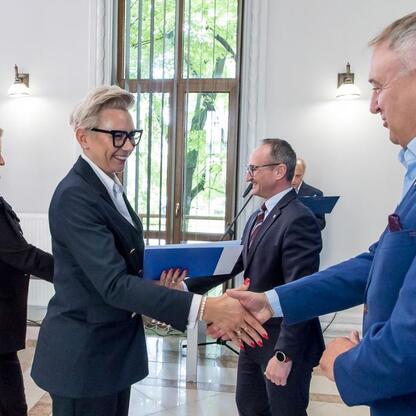 Wicemarszałek Grzegorz Boski i Marek Bieniek podczas ceremonii podpisania umów na modernizację dróg dojazdowych do terenów wiejskich. (wygenerowano przez AI)