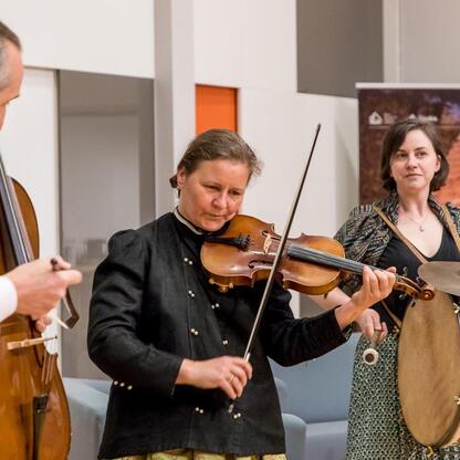 Ludzie w tradycyjnych strojach grają na instrumentach, uczcijąc 50-lecie Muzeum Górnego Śląska. (wygenerowano przez AI)