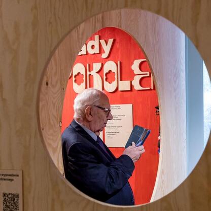 Mężczyzna w garniturze przegląda tablet, uczestnicząc w jubileuszowym świętowaniu Muzeum 