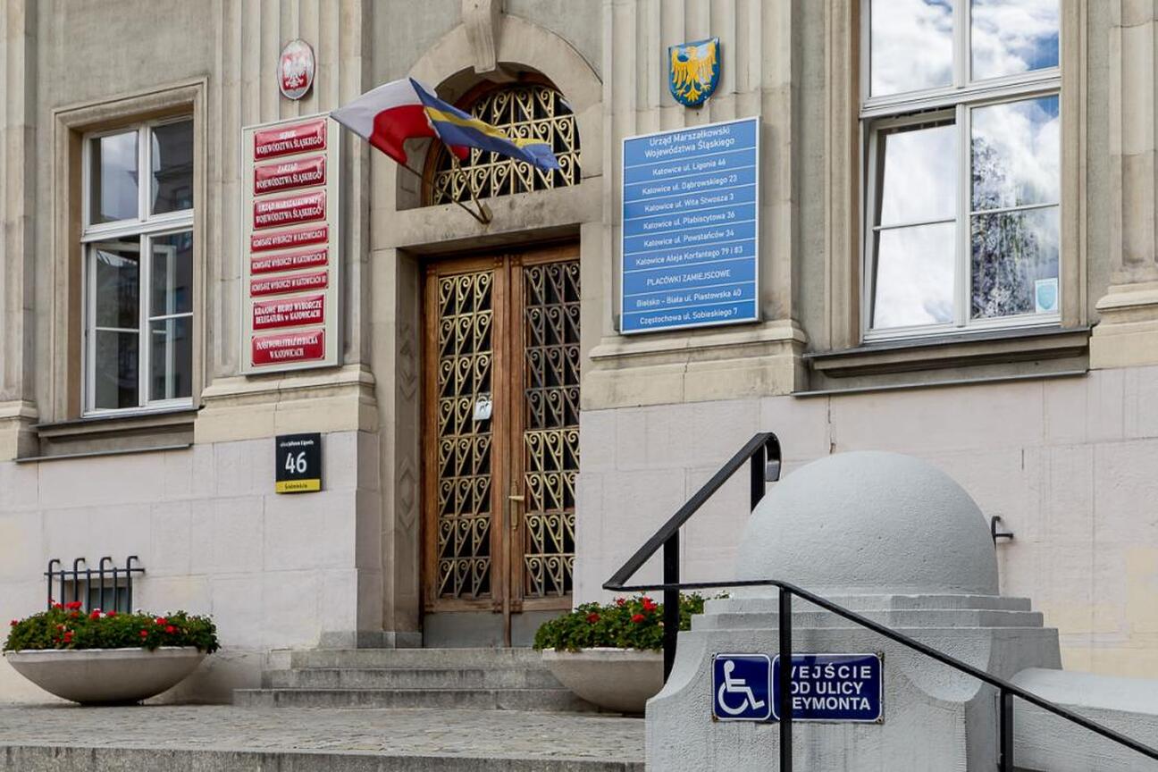 Wejście do Urzędu Marszałkowskiego Województwa Śląskiego w Katowicach, z godzinami pracy do 13:00 w dniu 30 maja 2025. (wygenerowano przez AI)
