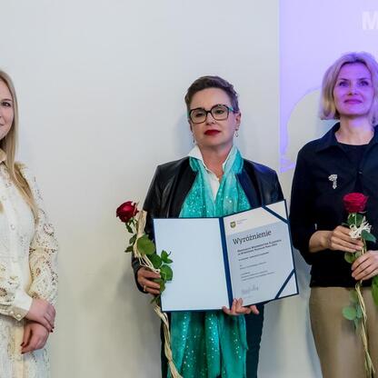 Trzy kobiety otrzymujące nagrody za wybitne osiągnięcia w muzealnictwie na Święcie Muzealnictwa w 2024 roku. (wygenerowano przez AI)