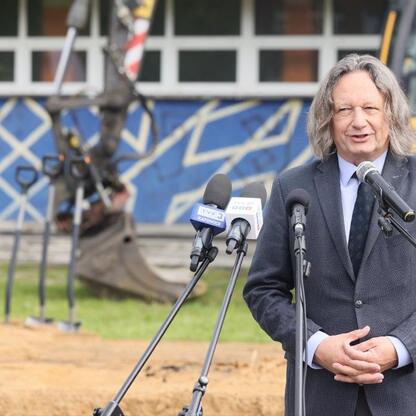 Podczas symbolicznego wmurowania kamienia węgielnego pod Śląskie Interdyscyplinarne Centrum Chemii, rektor Uniwersytetu Śląskiego przemawia do zgromadzonej publiczności. (wygenerowano przez AI)
