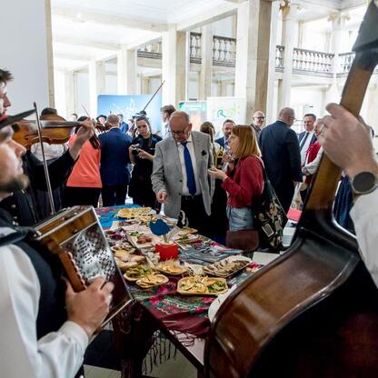 Widoczna jest scena z XV sesji Sejmiku Województwa Śląskiego, gdzie uczestnicy cieszą się folklorystycznym wydarzeniem. (wygenerowano przez AI)