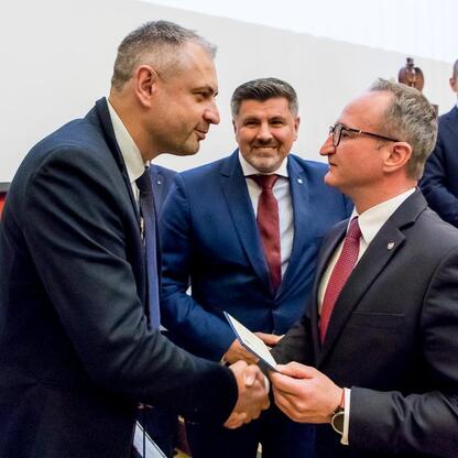 W trakcie XV sesji Sejmiku Województwa Śląskiego wicemarszałek Grzegorz Boski wręcza odznaki honorowe. (wygenerowano przez AI)