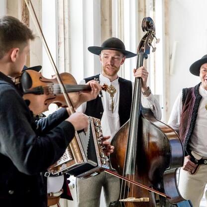 Muzycy w tradycyjnych strojach wykonują muzykę na festiwalu Tydzień Kultury Beskidzkiej w Śląsku. (wygenerowano przez AI)