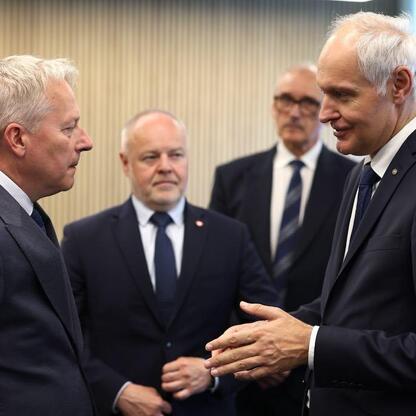 Grupa mężczyzn w strojach formalnych na otwarciu Centrum Technologii i Nauk Obliczeniowych na Politechnice Śląskiej. (wygenerowano przez AI)